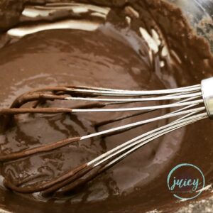 Whisking chocolate cupcake batter in a large mixing bowl