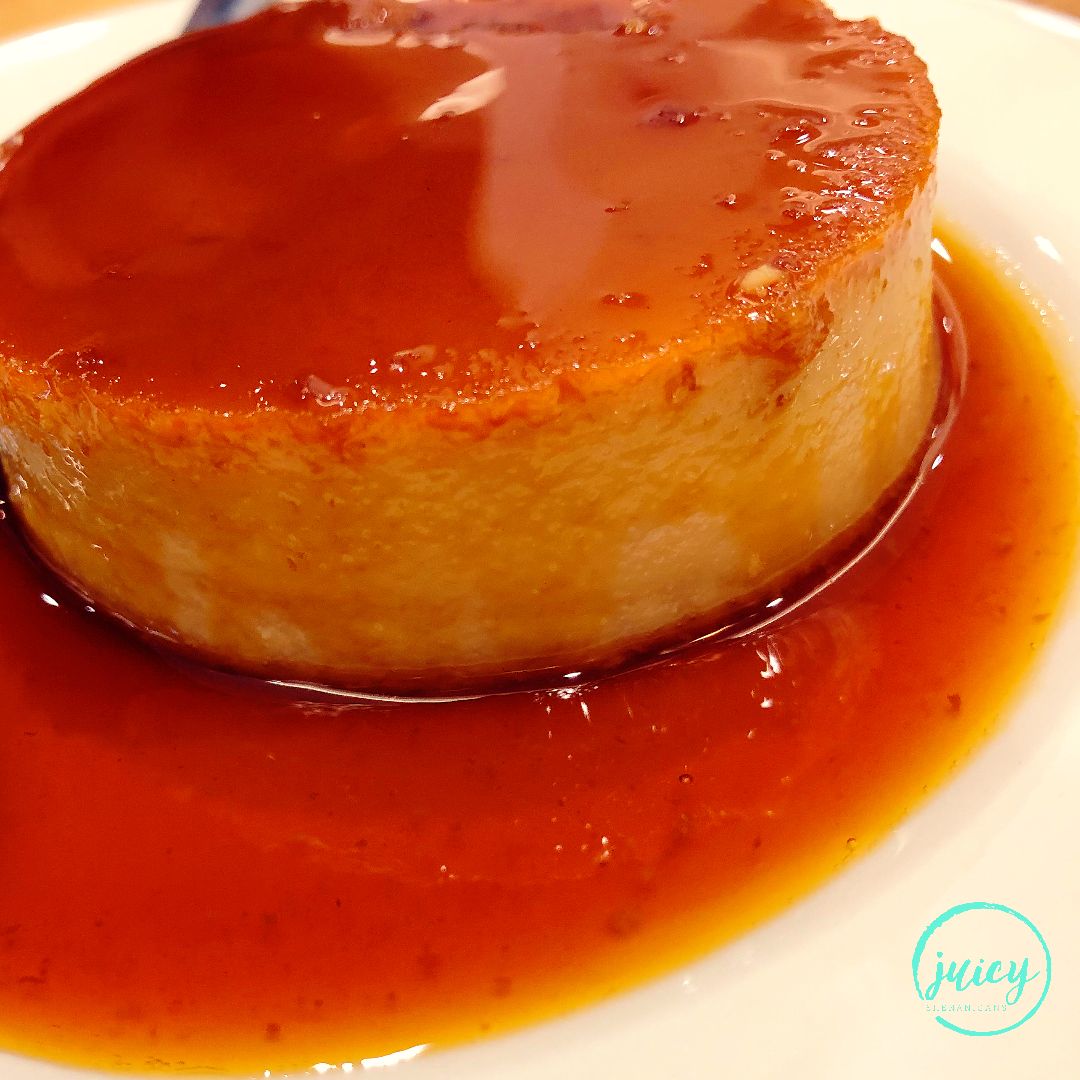 Filipino leche flan also known as creme caramel, served on a white platter topped with caramel sauce that overflows over the sides 