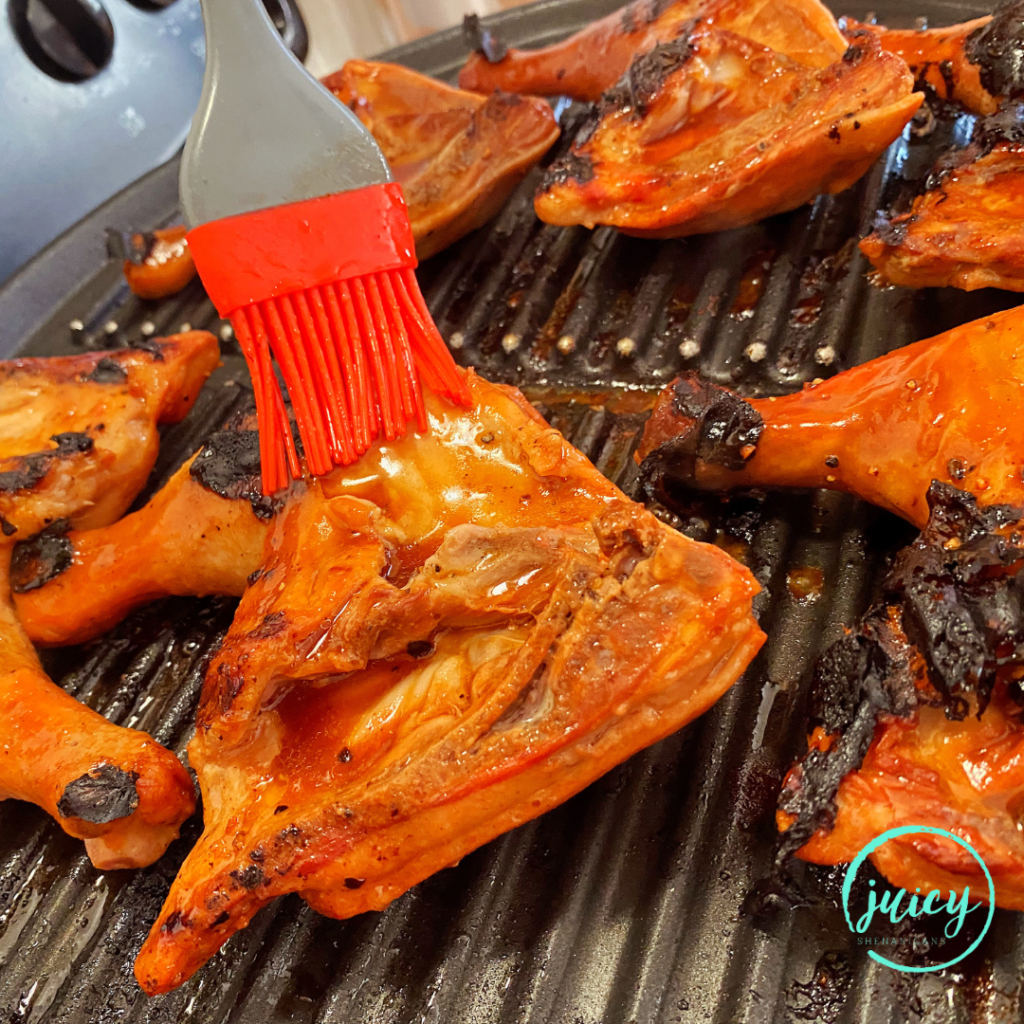 Filipino BBQ Chicken being basted with the marinade while grilling