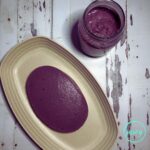 Top view of Filipino ube halaya served on an oval cream coloured platter, with ube jam in the background